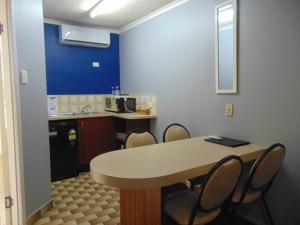 a kitchen with a table and chairs in a room at Rockhampton Court Motor Inn in Rockhampton