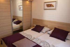 a small bedroom with a bed and a mirror at Apartments Sarc Rovinj in Rovinj