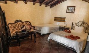 Zimmer mit 2 Betten, einem Sofa und einem Tisch in der Unterkunft Casa Catalina in Antigua Guatemala