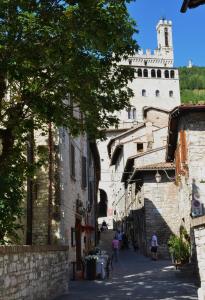 an alley with a large castle in the background at Locanda Del Duca in Gubbio +33 photos