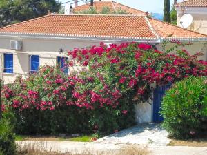 una casa con flores rosas delante de ella en Villa Oleander, en Spetses
