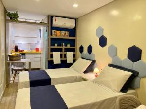 1 dormitorio con 2 camas, mesa y cocina en URBAN BOX HOUSE, en São Paulo