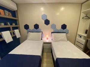 2 camas en una habitación pequeña con lámpara en URBAN BOX HOUSE en São Paulo