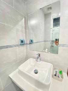 un bagno bianco con lavandino e specchio di Liên’s Mini Hotel a Phu Quoc