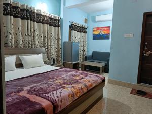 贾纳克布尔Hotel Vrindavan Palace的房间里有一张床和一张沙发的卧室