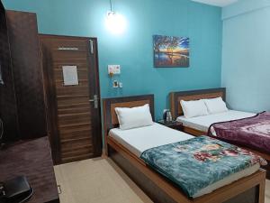 2 camas en una habitación con paredes azules en Hotel Vrindavan Palace, en Janakpur