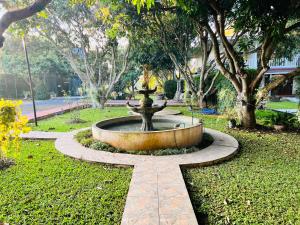 una fuente en medio de un parque con árboles en Jardin De Mangue Pakchong, en Pak Chong