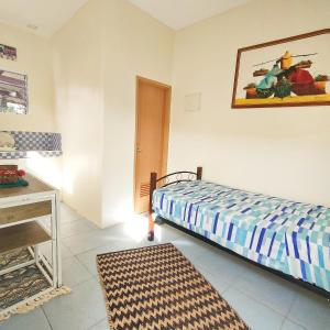 1 dormitorio con 1 cama, 1 mesa y 1 foto en Intoy's Place, en Panglao
