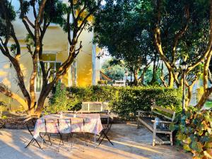 a table and chairs in a park with trees at Jardin De Mangue Pakchong in Pak Chong