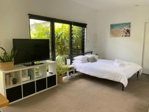 a bedroom with a bed and a flat screen tv at Bali In Berrara in Berrara