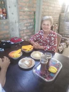 an older woman sitting at a table with food at Loku Mirissa in Mirissa