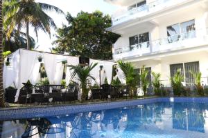 a hotel with a swimming pool in front of a building at La Vera Boutique Hotel, Mandrem in Mandrem