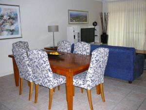mesa de comedor y sillas con sofá azul en Magnolia Lane Apartments, en Twin Waters