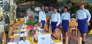 a group of three people standing in front of tables at Tan-Swiss Lodge in Mikumi