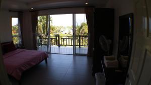 a room with a bed and a view of a balcony at Sea Lavender Villa in Ko Chang