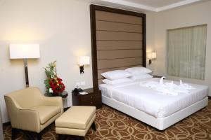 a hotel room with a bed and a chair at YN Hotels in Bengaluru +216 photos