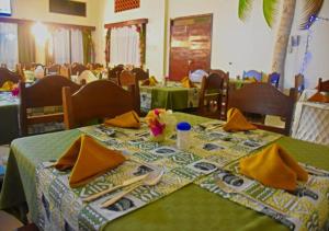a table with a green table cloth and utensils on it at Watamu Adventist Beach Resort in Watamu