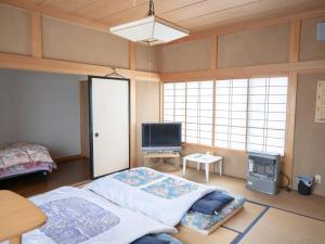 秋田市にあるみんなの実家門脇家のベッド1台、薄型テレビが備わる客室です。