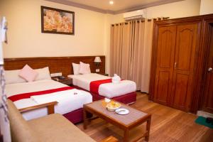 a hotel room with two beds and a couch at Hotel The White Lotus View Pvt Ltd in Bhairāhawā