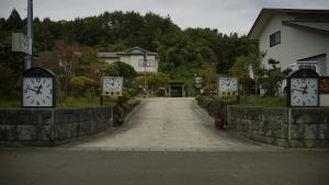 a street with clocks on the sides of a road at みんなの実家門脇家 in Akita