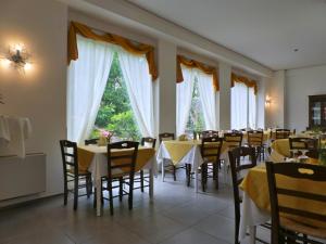 a dining room with tables and chairs and windows at Hotel La Congiura dei Baroni in Teggiano
