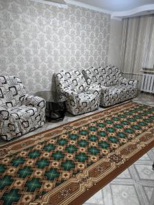 uma sala de estar com dois sofás e um tapete em Квартира в районе жд вокзала em Shchuchinsk
