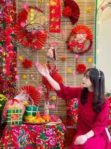 a woman is standing in front of a wall with red umbrellas at May Ho Hotel Sapa in Sa Pa