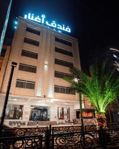 a building with a sign on top of it at Aghnar Hotel in An Najaf