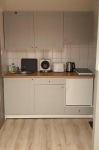 eine Küche mit weißen Schränken und einer Arbeitsplatte in der Unterkunft MŁAWSKA 33 in Rypin