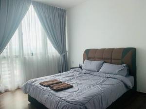 Un dormitorio con una cama con dos toallas encima. en Rohani Jazz Suites 4 @ Vivacity Megamall, en Kuching