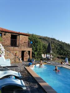 um grupo de pessoas numa piscina ao lado de uma casa em Bela Vista Alqueve - 2 houses with pool, 2 casas com piscina em Arganil