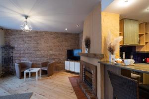 a kitchen and living room with a brick wall at Old Riga Aldaru Street Historic One Bedroom Apartment in Riga