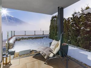a room with a snow covered balcony with a chair at Van's Place, Luxury Apartment in Kaltenbach