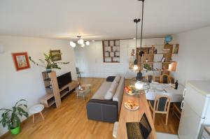 a living room with a couch and a table at Shine24 - Spacious and bright apartment in Novi Sad +19 photos
