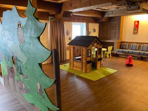 una habitación con una sala de juegos para niños con una casa de juegos en Berghoteltirol en Jungholz