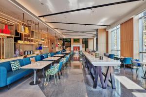 a dining room with tables and blue chairs at Artyzen Habitat Qiantan Shanghai in Shanghai