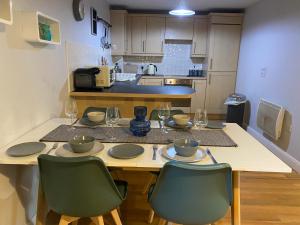 uma cozinha com uma mesa com duas cadeiras e um estofador de mesa em Lime Tree Apartment em Coventry