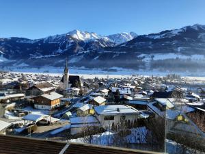 a town covered in snow with mountains in the background at Glas House - Design Holiday Home in Piesendorf