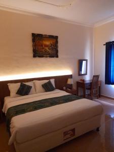 1 dormitorio con 1 cama grande y escritorio en Kuta Paradise, en Lombok