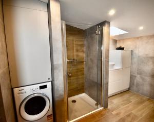 a bathroom with a shower and a washing machine at Kraków Krib in Kraków