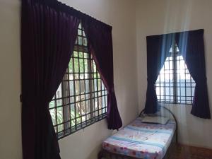 a room with two windows and a bed in it at Homestay Chik Da in Alor Setar