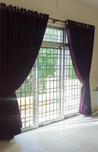 a large window with purple curtains in a room at Homestay Chik Da in Alor Setar