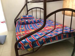 a metal bunk bed with a colorful blanket on it at Homestay Chik Da in Alor Setar