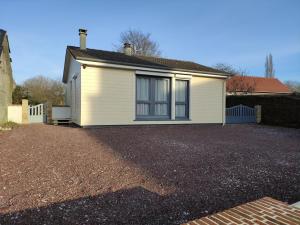 a white house with a gravel driveway in front of it at Gite du village in Estréboeuf