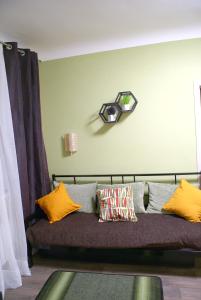 a couch with pillows and a clock on the wall at Apartments KVADRO Dnepr, ул Холодноярская, 19, Метеор Апполо Рабочая Титова in Dnipro