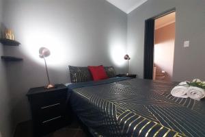 um quarto com uma cama com dois candeeiros em Cozy Hatfield Condo em Pretoria