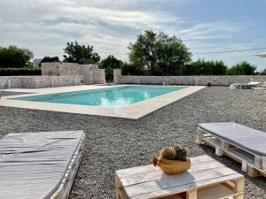 basen na dziedzińcu z dwoma łóżkami i stołem w obiekcie Loggia Dei Lezzi w mieście Noci