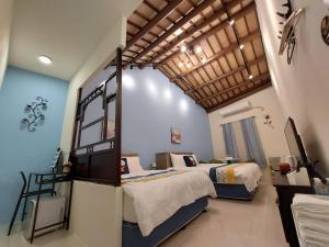 um quarto com 2 camas e uma grande janela em Lubi Inn em Lukang
