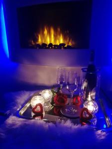 un vassoio con bicchieri da vino, candele e un camino di Il cielo in una stanza a Itri
