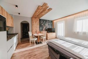 1 dormitorio con 1 cama y 1 mesa con sillas en Cesa Edelweiss Living & Spa, en Campitello di Fassa